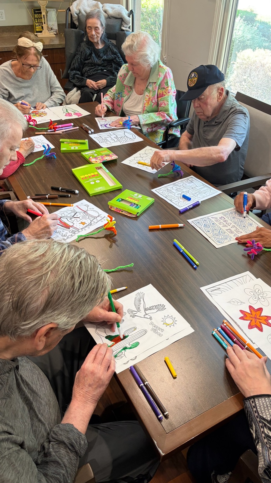 Close-up of residents coloring detailed patterns with markers and pipe cleaners